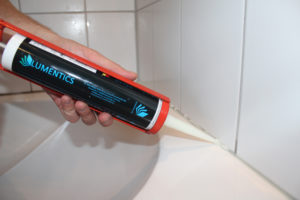 Leuchtsilikon wird mit der Kartusche als Fuge an der Badewanne aufgetragen