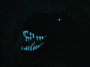 Dinosaurier-Bild mit grün-blauer lumentics-Leuchtfarbe im Dunklen