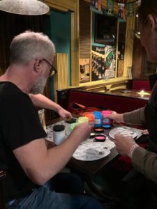 Teilnehmer mischt Leuchtfarben beim Malabend im Pub