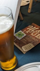 Bier und MalPub-Flyer mit Kleeblatt-Motiv auf dem Tisch
