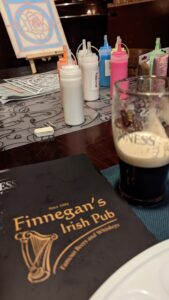 Malutensilien, Leuchtfarben und ein Guinness auf dem Tisch im Finnegan’s Irish Pub