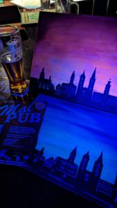 Gemalte Altenburger Skyline vor violettem Himmel unter Schwarzlicht