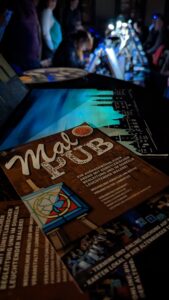 MalPub-Flyer und leuchtendes Bild auf dem Tisch