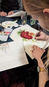 Teilnehmerin malt ein Herz mit Blumen in Aquarell