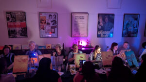 Gäste malen beim NachleuchtBar-Abend im violett beleuchteten Saal